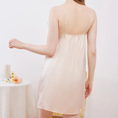 Woman wearing a light pink slip dress against a white background