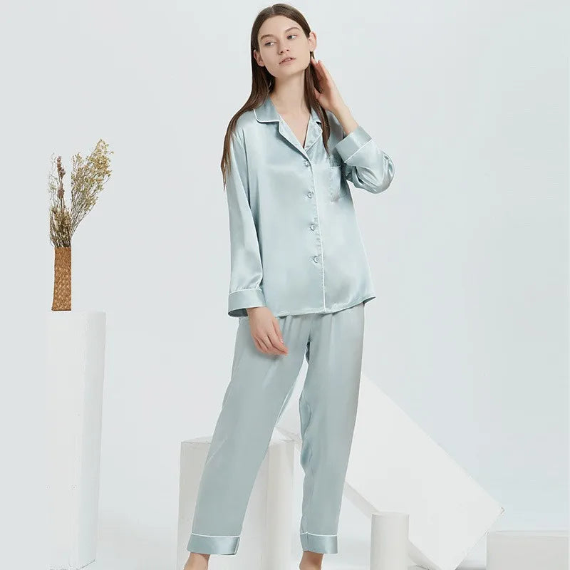 Woman wearing light blue satin pajamas on a white background