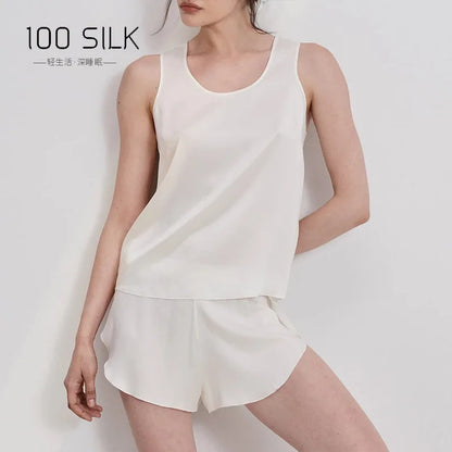 Woman wearing a white silk outfit with '100 SILK' branding on a light background