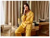 Woman in yellow outfit sitting on a couch in a room with a window.