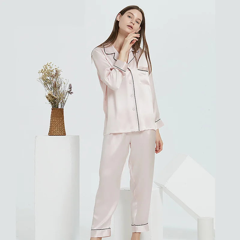 Woman wearing a light pink satin pajama set against a white background