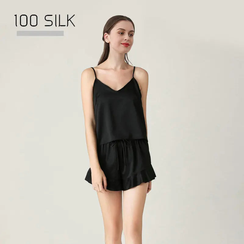 Woman wearing a black silk dress with '100 Silk' text on a light gray background