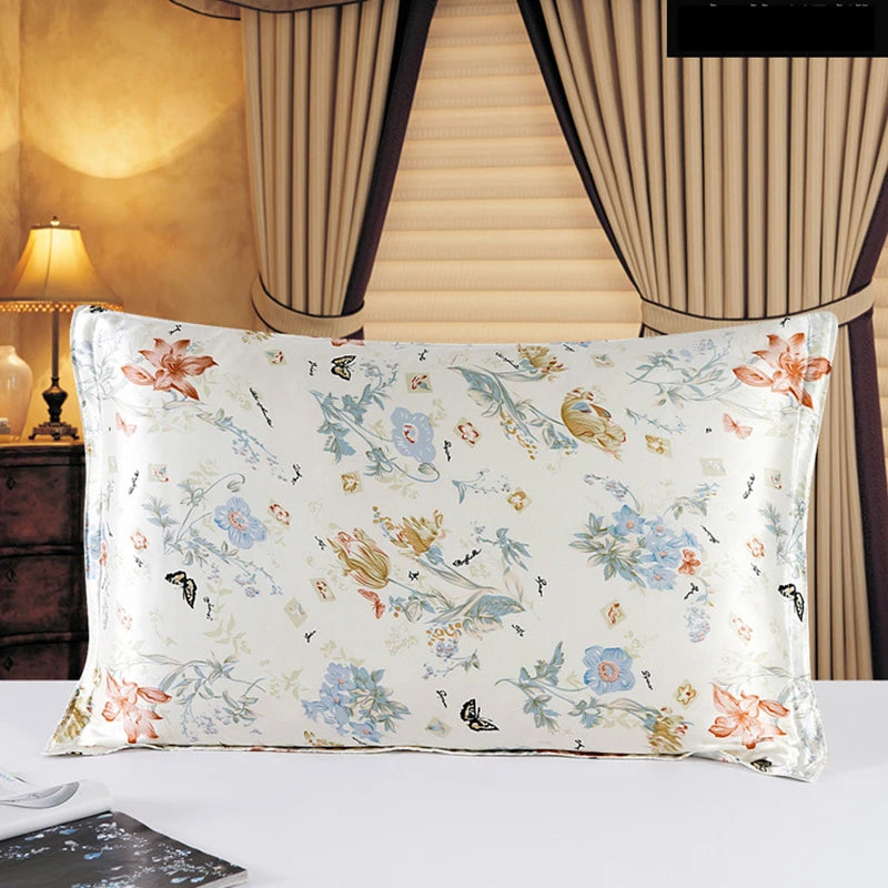 Floral-patterned pillow on a bed with curtains and lamp in the background
