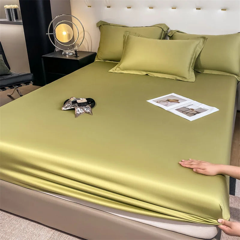 Person holding a green satin sheet over a bed in a bedroom setting.