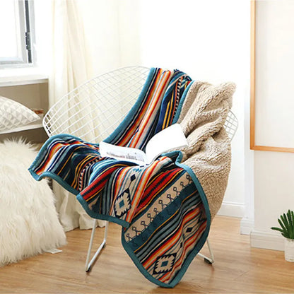 Colorful patterned blanket draped over a chair in a room with light decor.