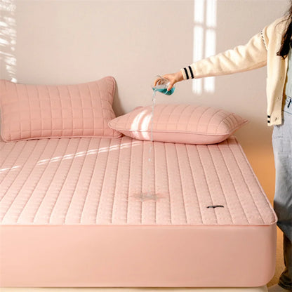 Person applying a product to a pink mattress cover in a bright room.