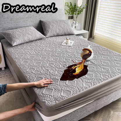 Gray textured mattress cover on a bed with a person's hands lifting it, showing a coffee cup and saucer underneath.
